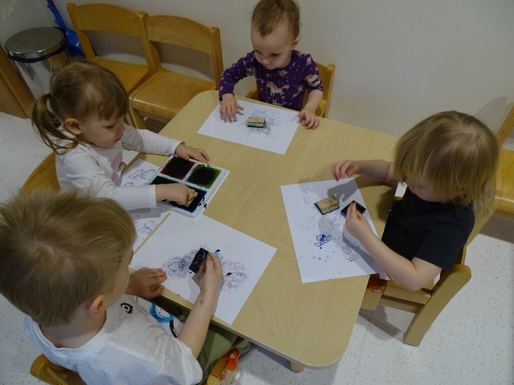 Dziewczynka moczy pieczątkę w tuszu