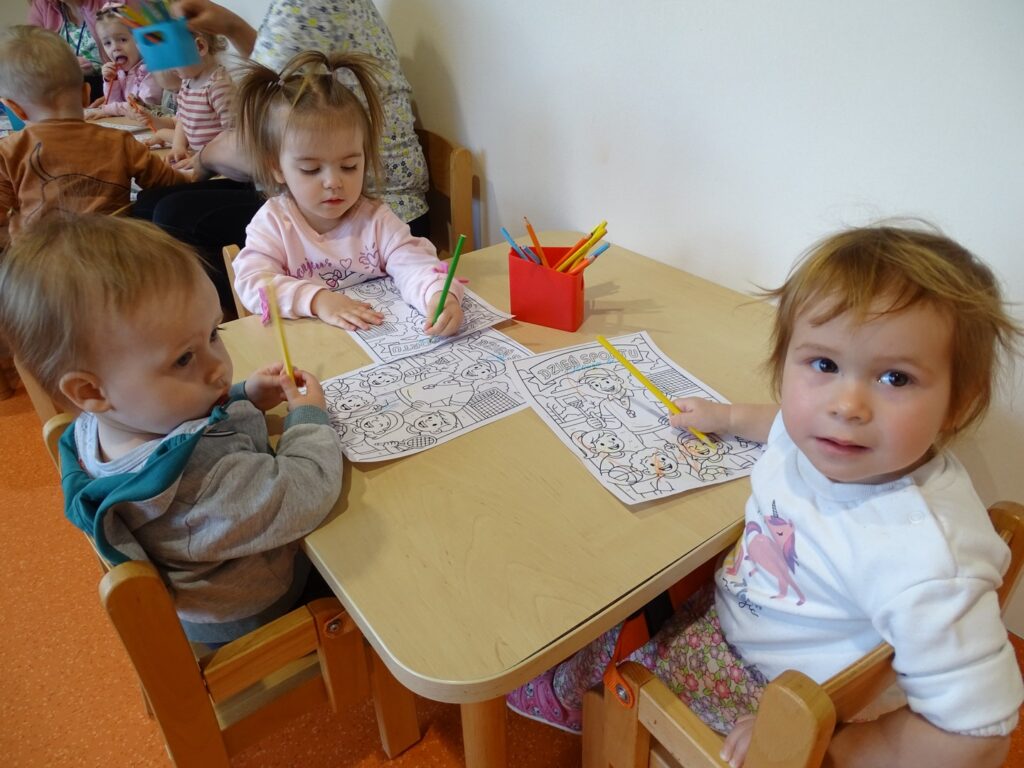 Dziewczynka trzyma zieloną kredkę
