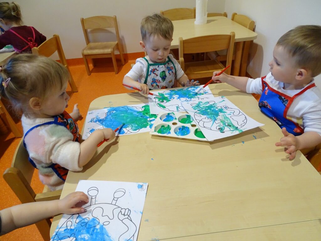 Dzieci malują farbami przy stoliku