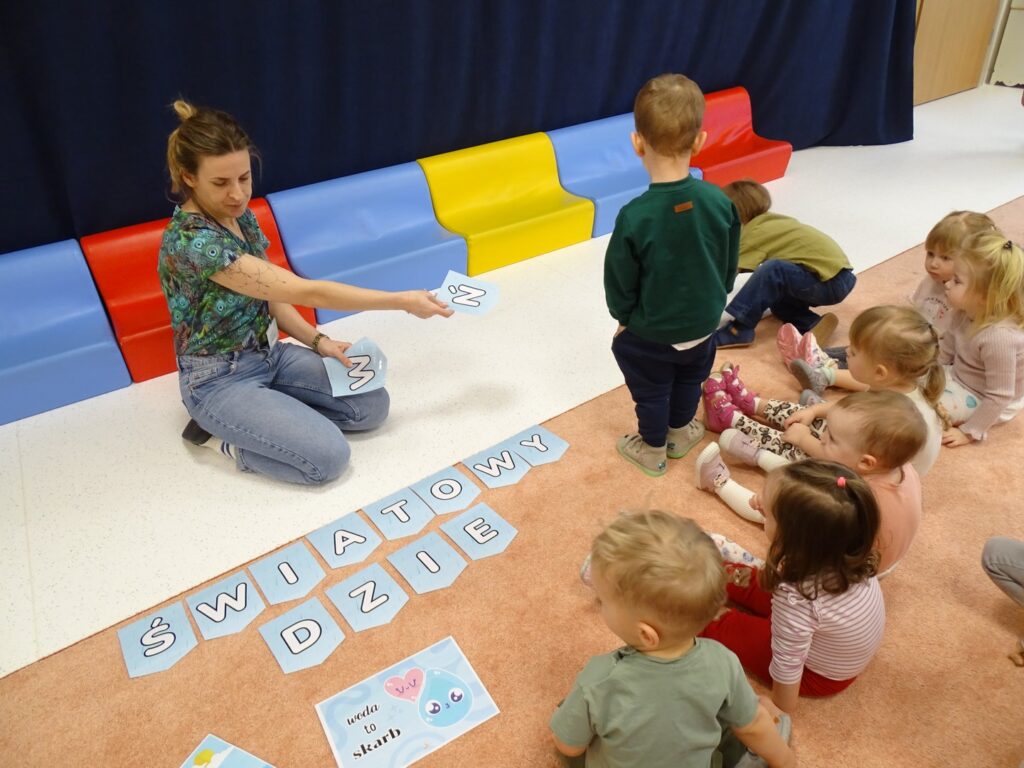 Dzieci próbują ułożyć napis