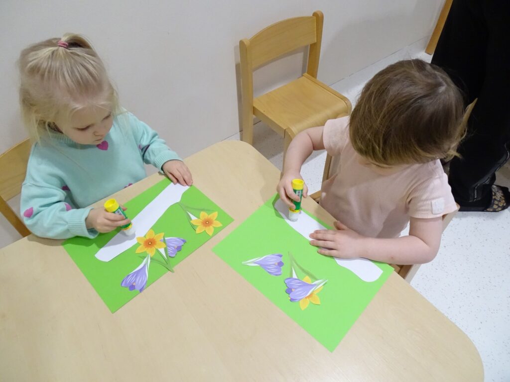 Dziewczynki naklejają kwiaty