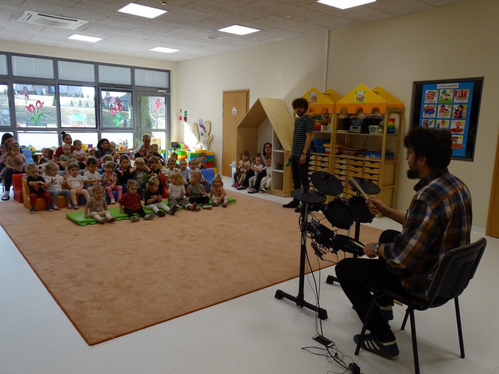 Pan prezentuje dzieciom jak gra na perkusji