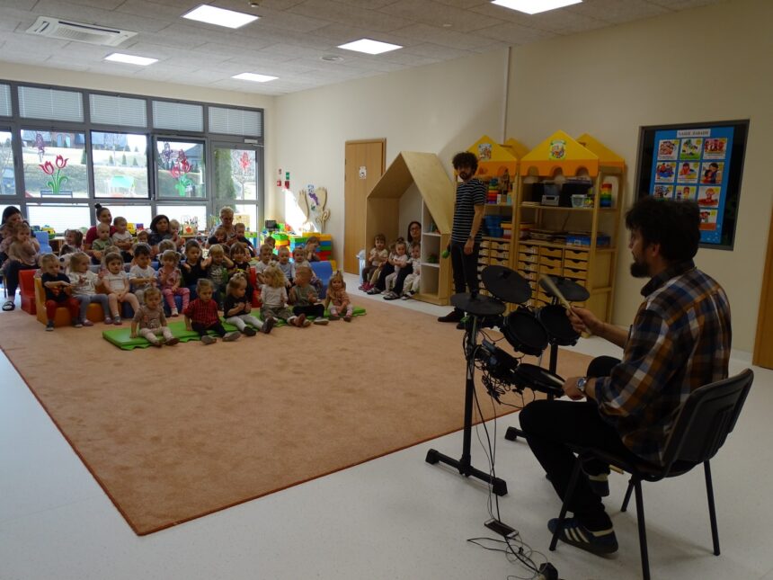 Pan prezentuje dzieciom jak gra na perkusji