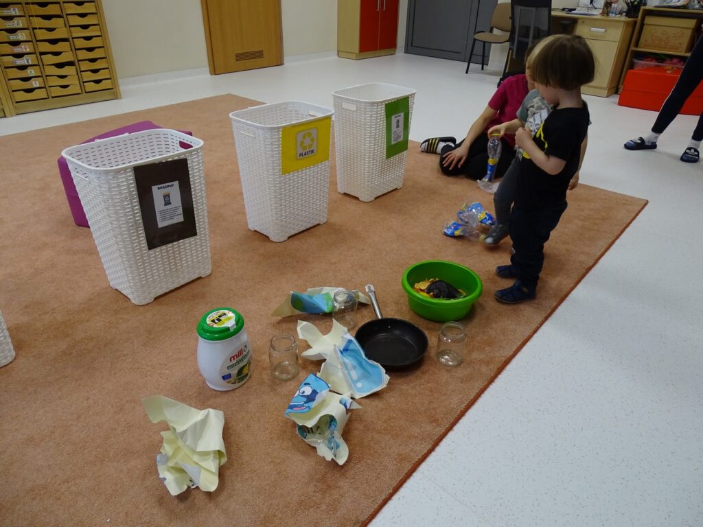 Chłopczyk podnosi plastikową butelkę