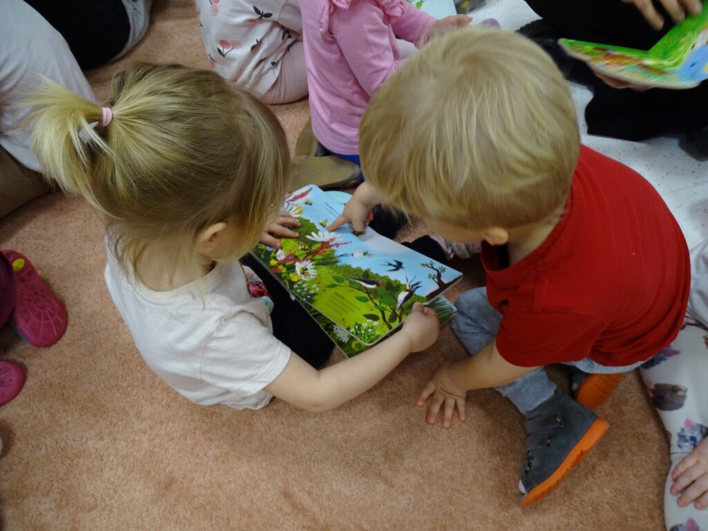 Chłopczyk pokazuje dziewczynce obrazek w książce