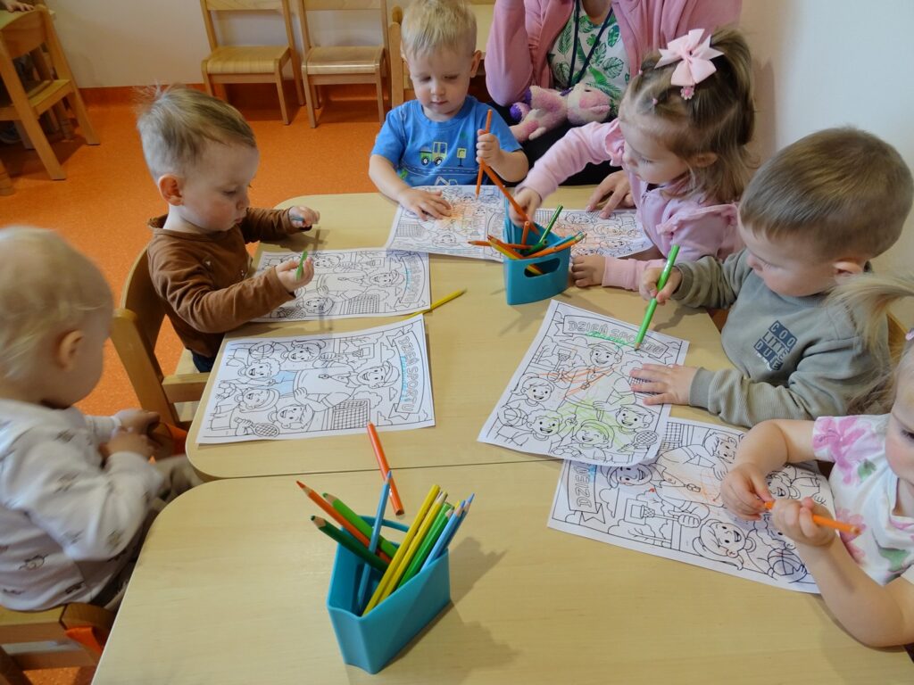 Dzieci kolorują przy stolikach