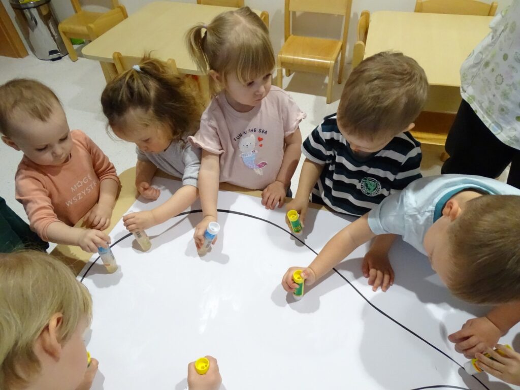 Dzieci smarują karton klejem