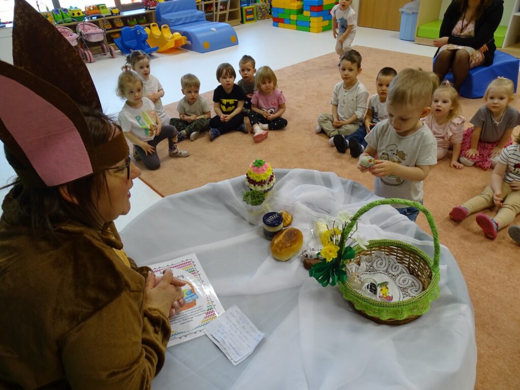 Chłopczyk wkłada jajko do koszyczka