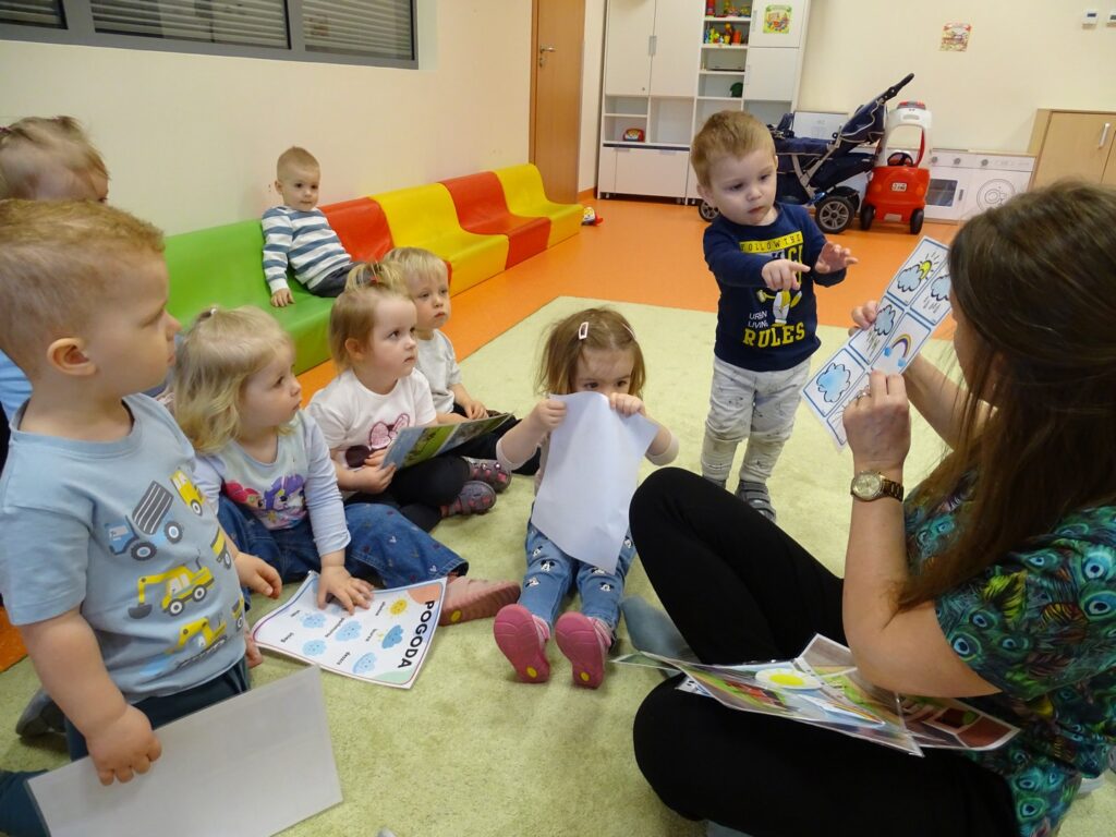 Chłopczyk wskazuje palcem na kartę pracy