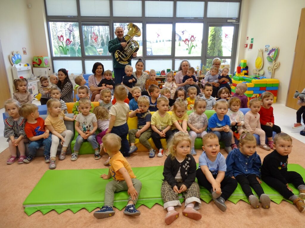 Dzieci pozują do wspólnego zdjęcia z gościem