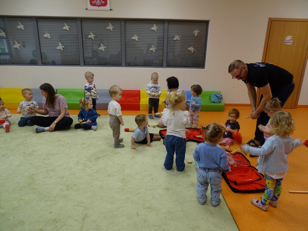 Dzieci siadają na dywanie