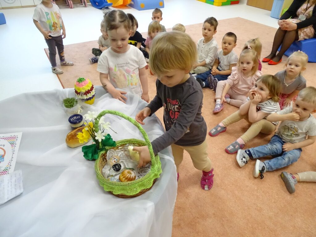 Dziewczynka wkłada baranka do koszyczka