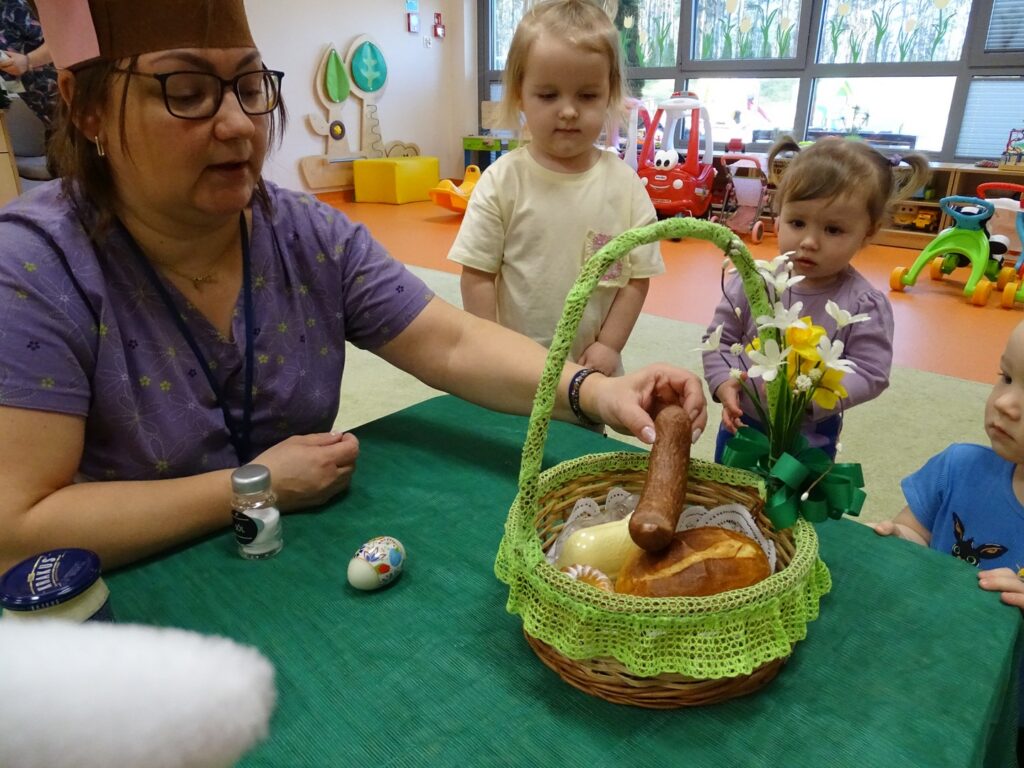 Opiekun wkłada kiełbasę do koszyczka