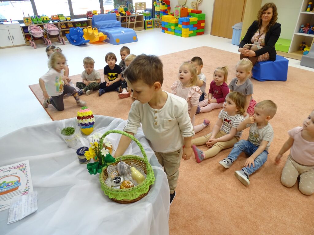 Chłopczyk ogląda zawartość wielkanocnego koszyczka
