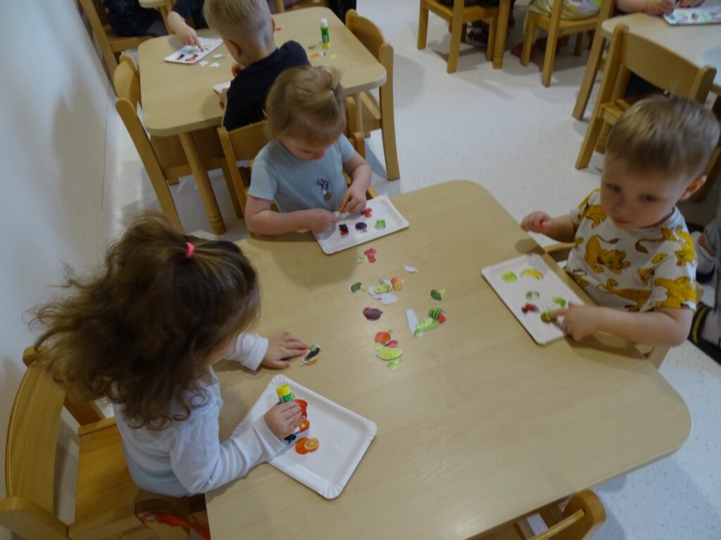 Dzieci naklejają obrazki na talerzyk