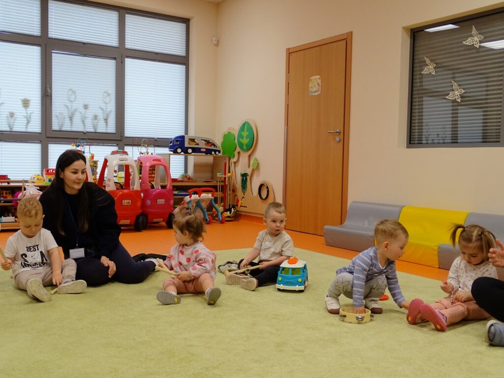 Dzieci siedzą na dywanie