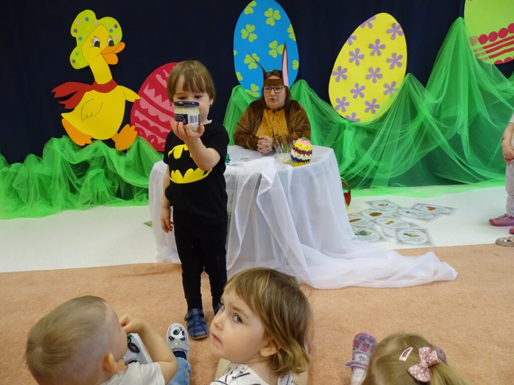 Chłopczyk pokazuje dzieciom chrzan