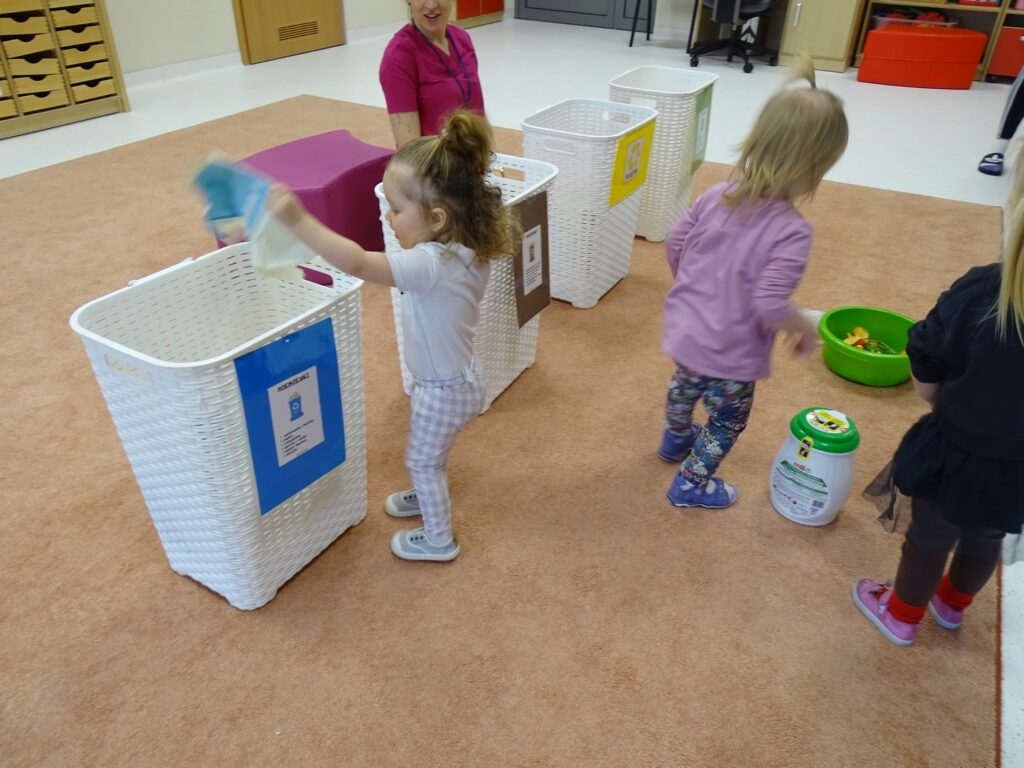 Dziewczynka wrzuca papier do kosza