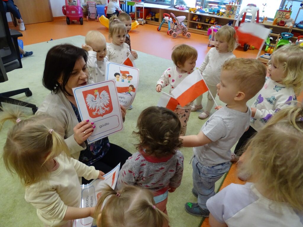 Pani pokazuje dzieciom karty pracy