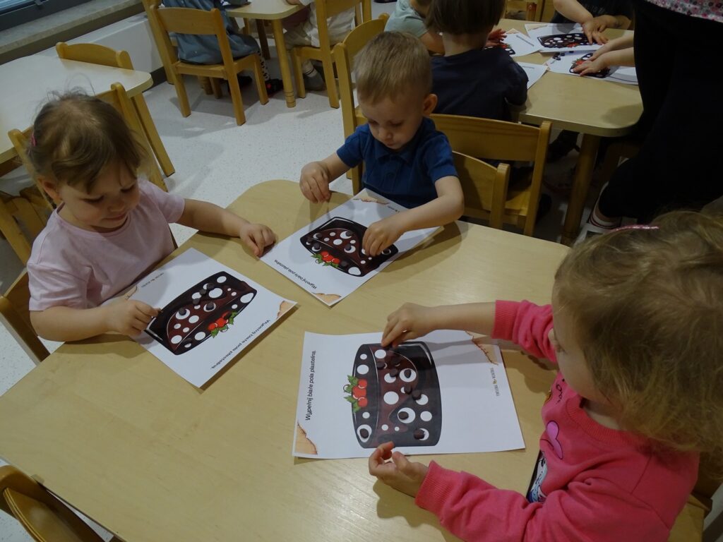 Dzieci wyklejają obrazek plasteliną