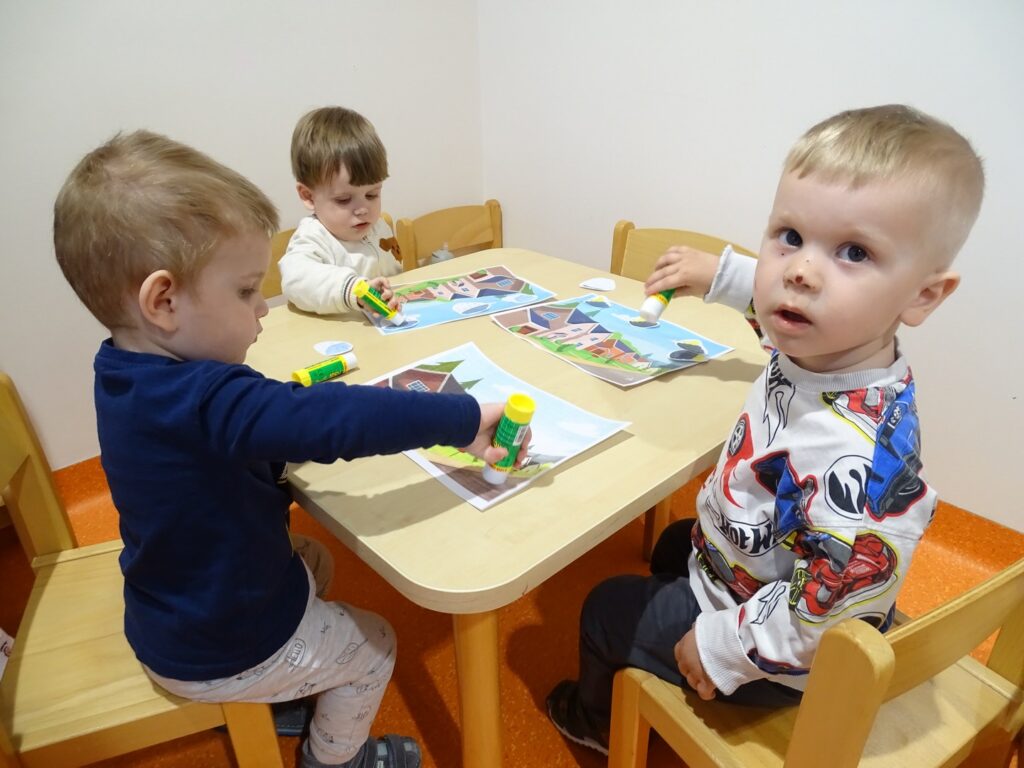 Trzech chłopców wykonuje pracę plastyczną