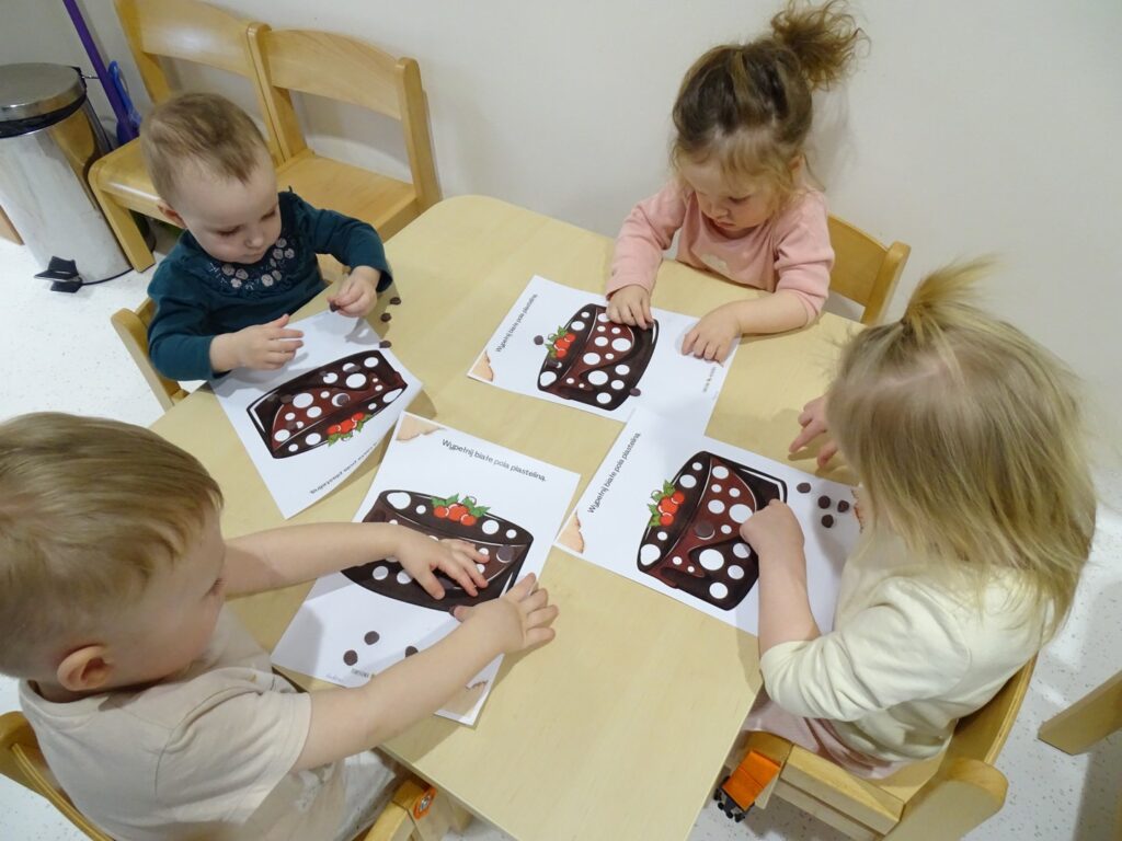 Dzieci naklejają plastelinę