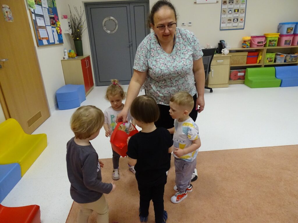 Dzieci wkładają jajeczka do koszyczka