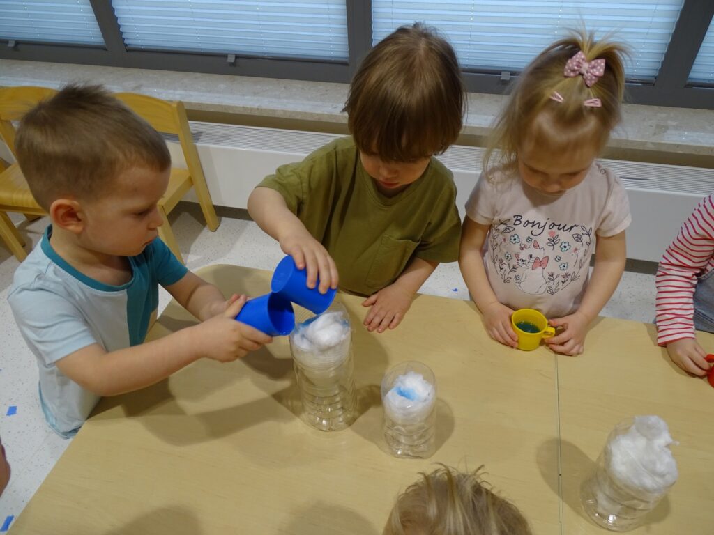 Chłopcy wlewają wodę na watę