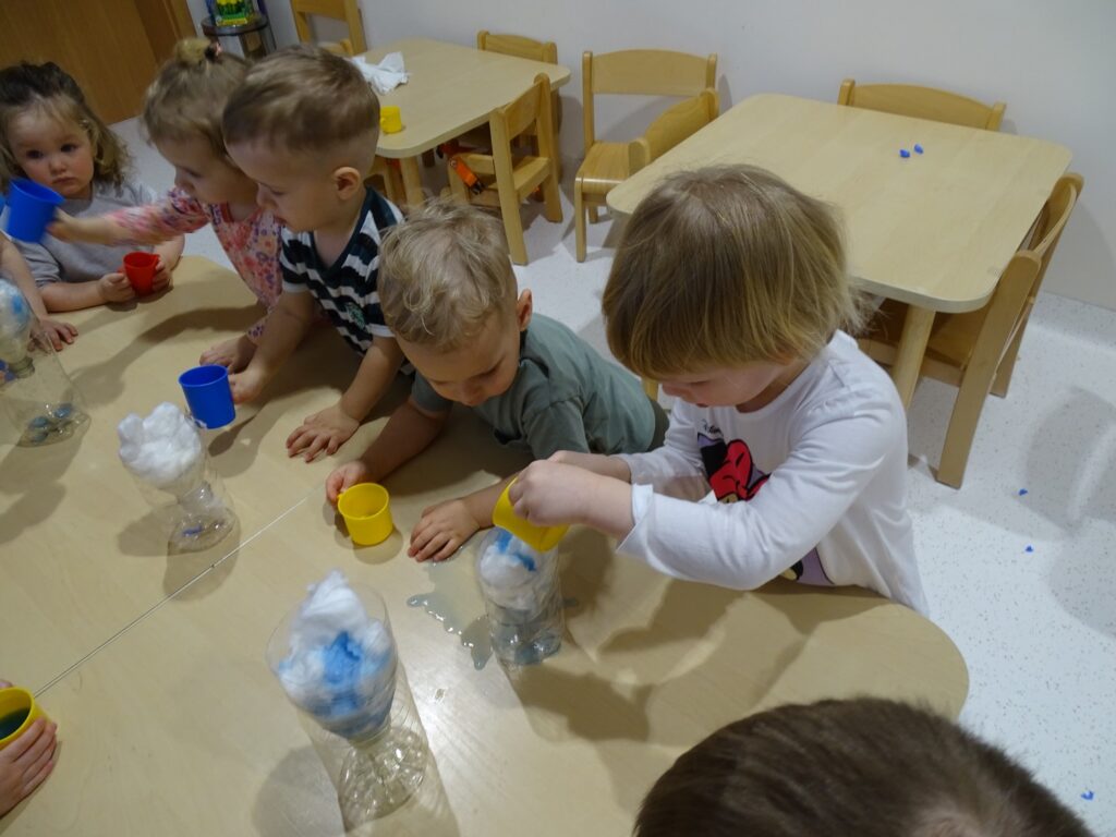 Dzieci próbują wykonać eksperyment z wodą