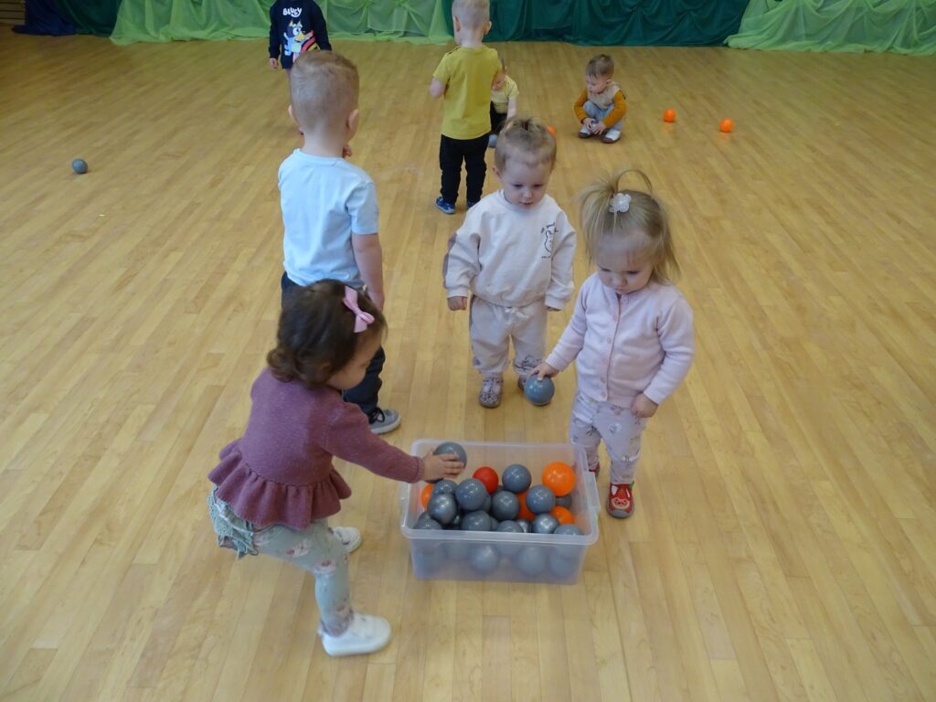 Dziewczynka wrzuca piłeczkę do pudełka