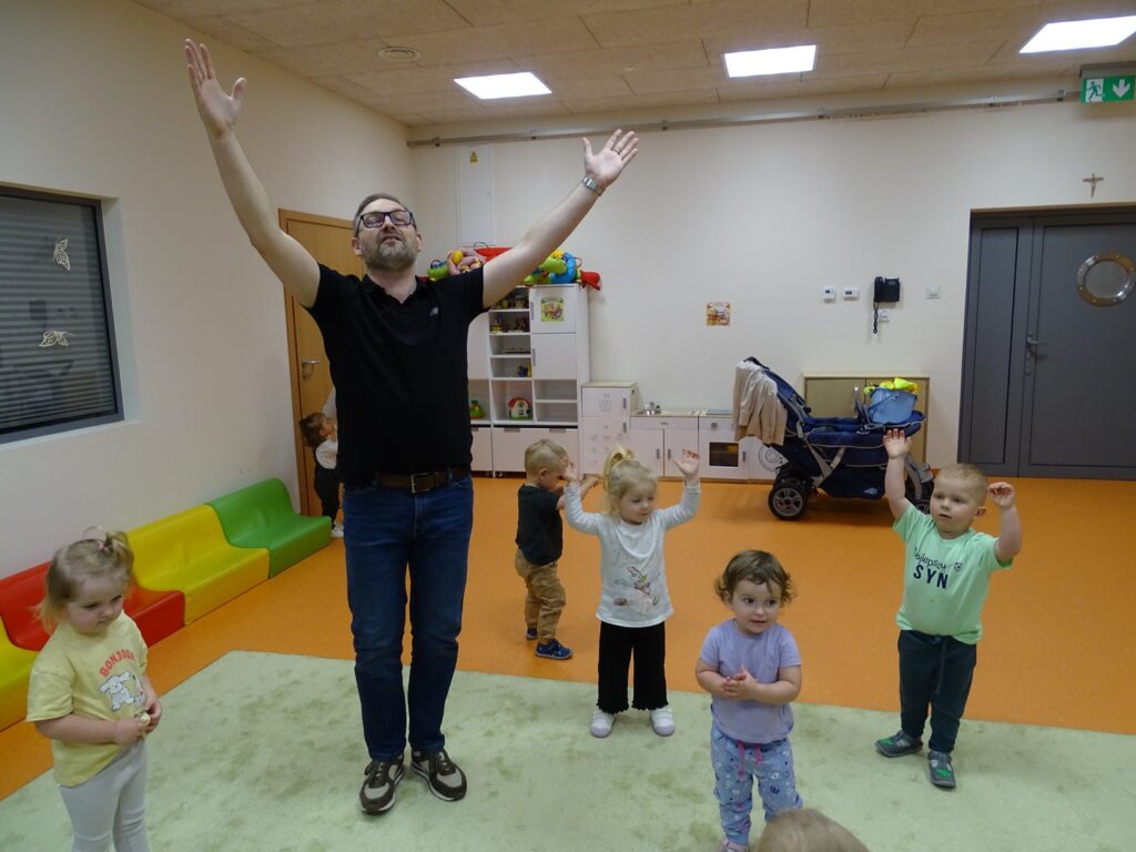 Pan Arek wraz z dziećmi podnosi do góry ręce