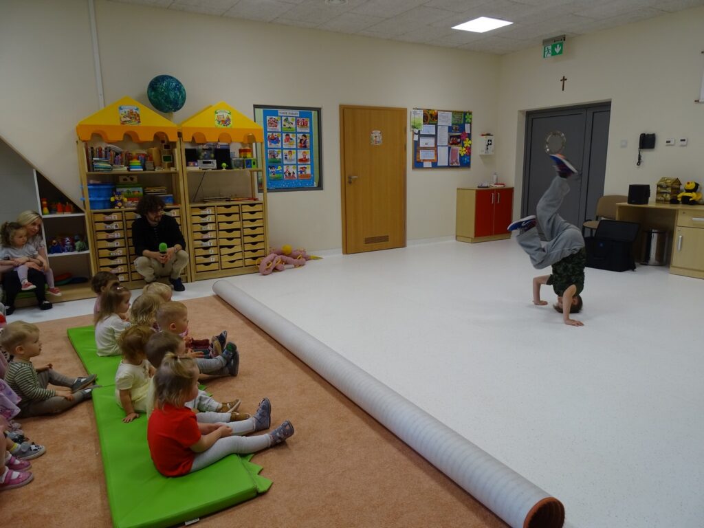 Dzieci oglądają chłopca tańczącego breakdance