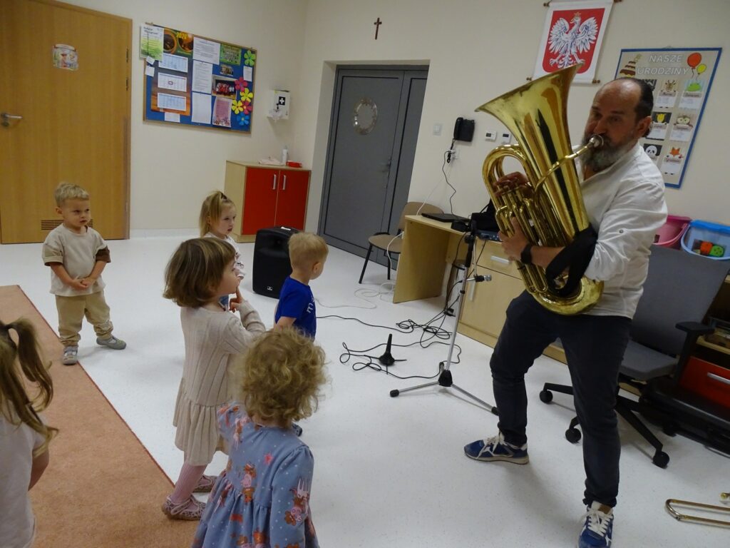 Pan gra na instrumencie a dzieci tańczą