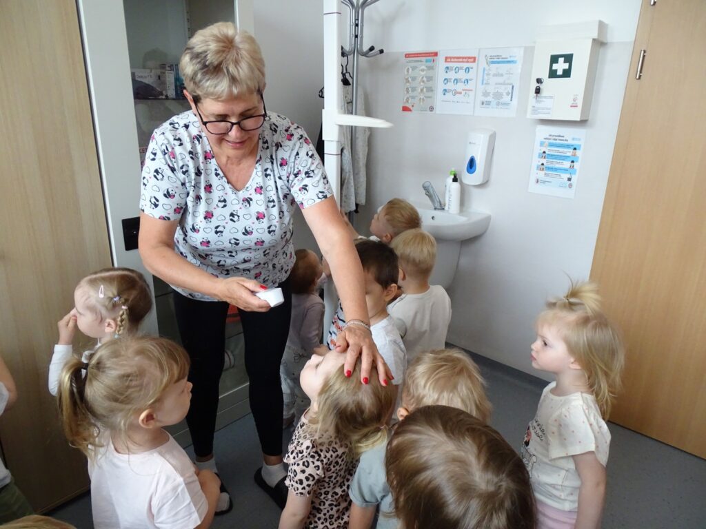 Pielęgniarka mierzy dziecku gorączkę