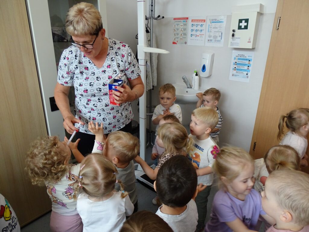 Pani pielęgniarka pokazuje dzieciom syrop