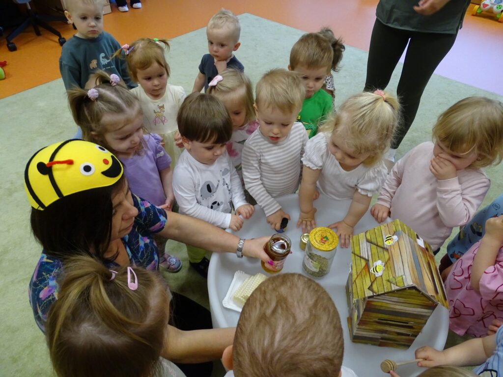 Pani pokazuje dzieciom miód