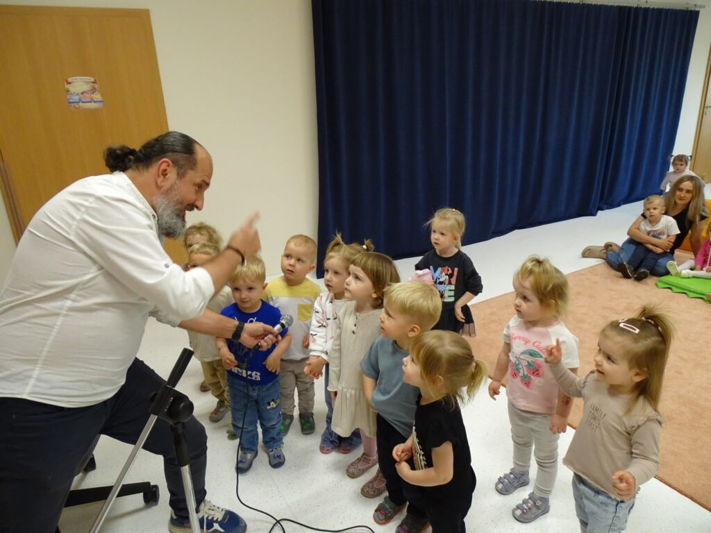 Pan pokazuje dzieciom mikrofon