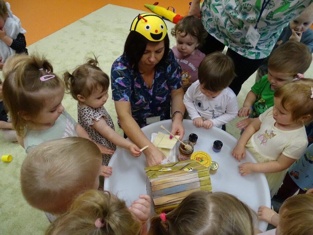  Pani rozdaje dzieciom wafelki z miodem
