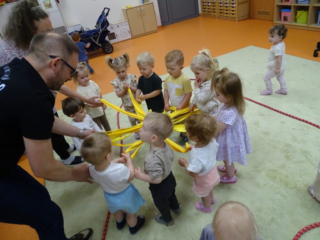 Pan pokazuje dzieciom zabawę szarfami