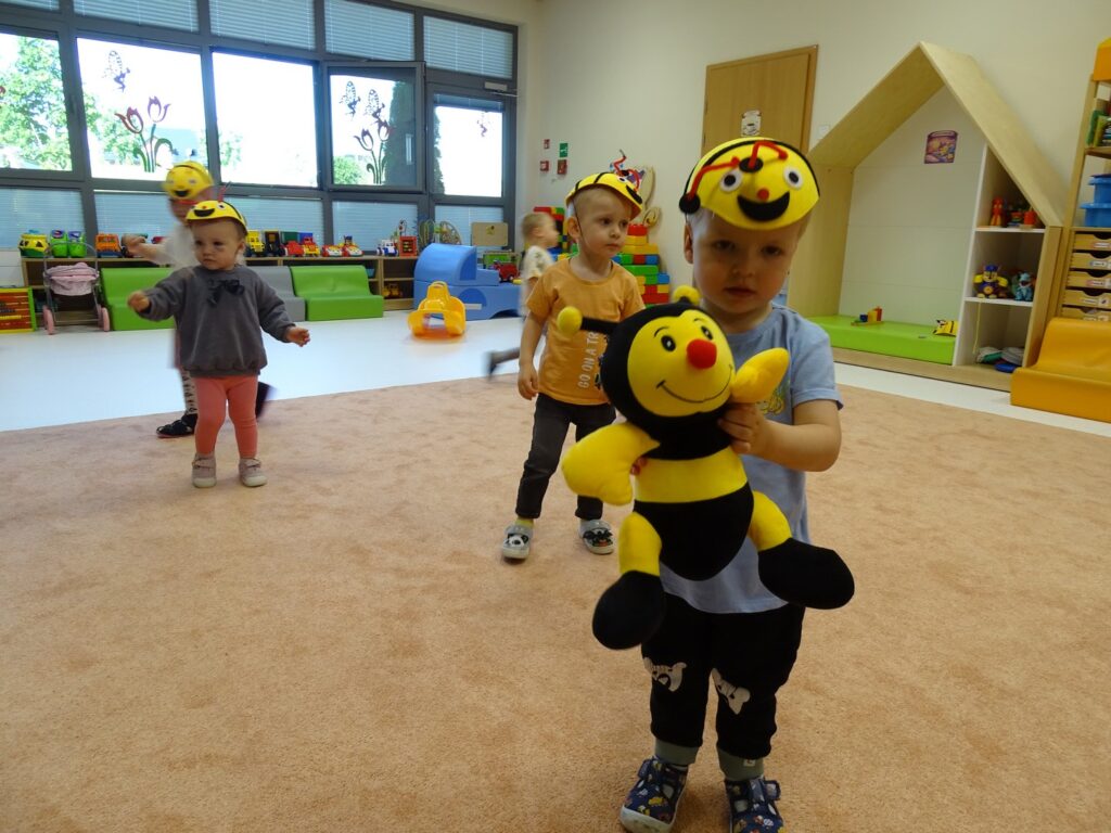 Chłopczyk pozuje z maskotką pszczółką