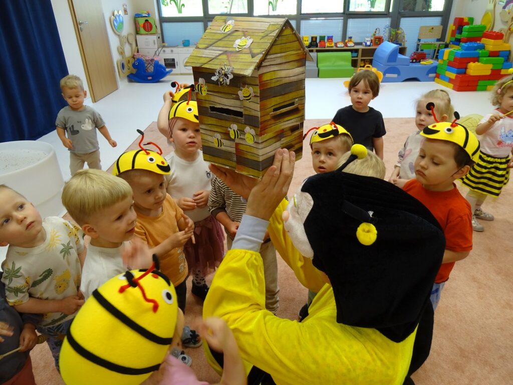 Opiekunka pokazuje dzieciom budowę ula