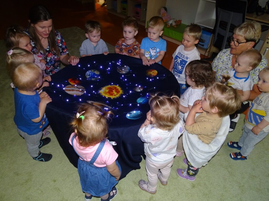 Dzieci z zainteresowaniem oglądają planety
