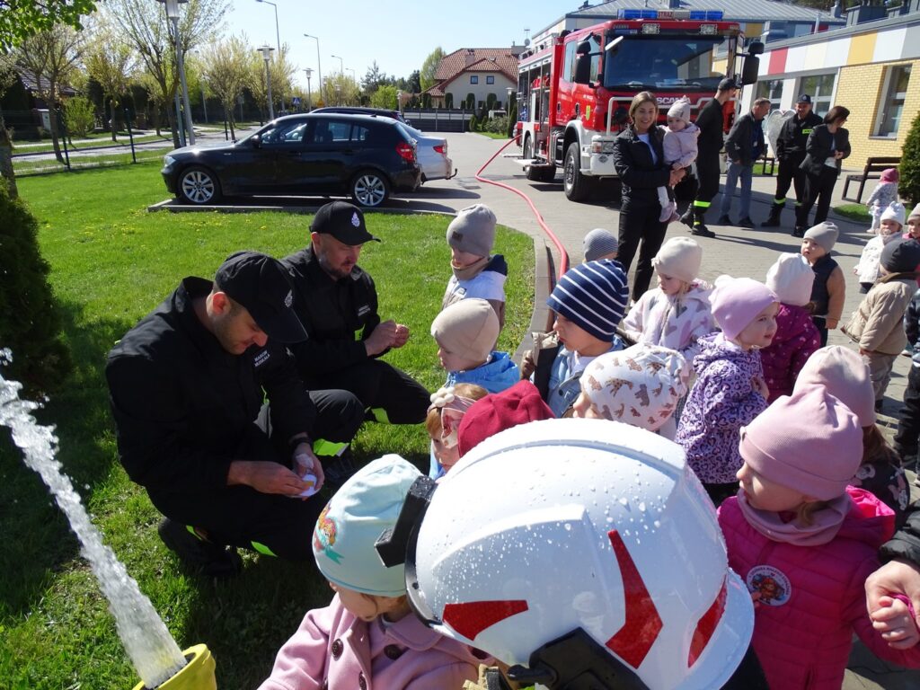 Strażacy wręczaja dzieciom odznaki