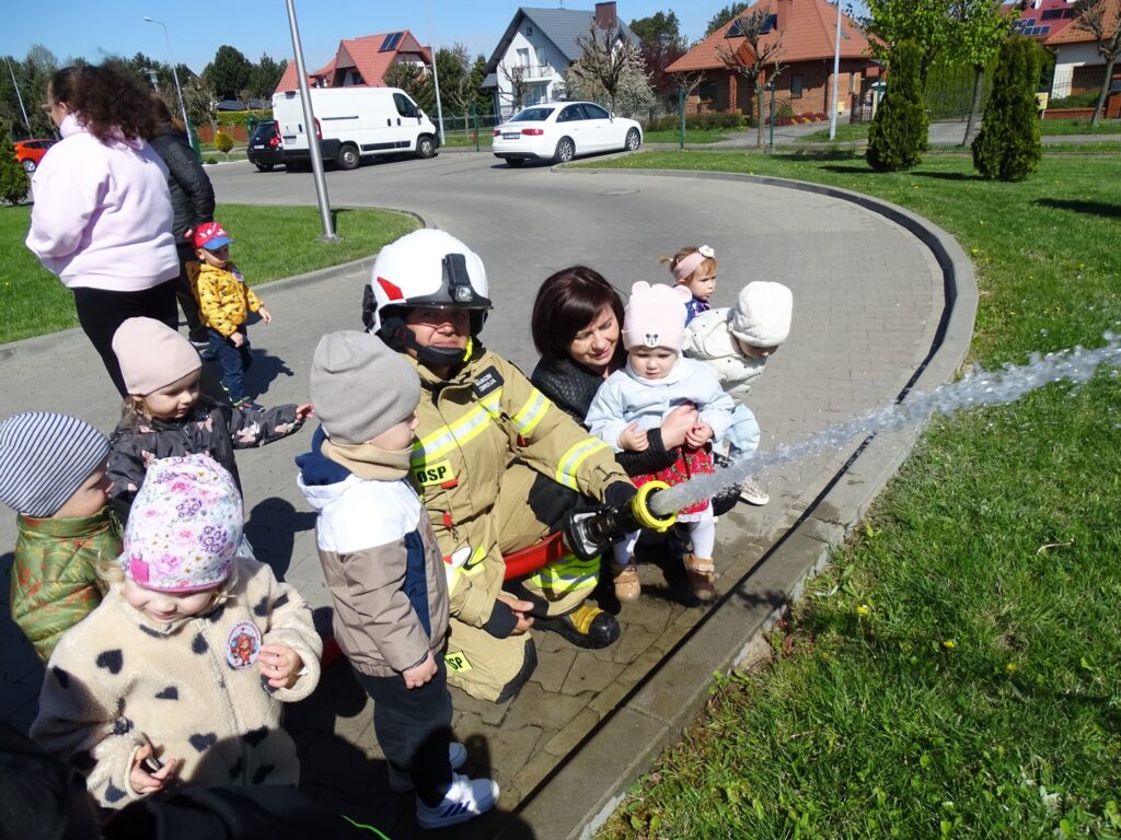 Dziewczynka wraz z Panią i dziecmi przyglądają się