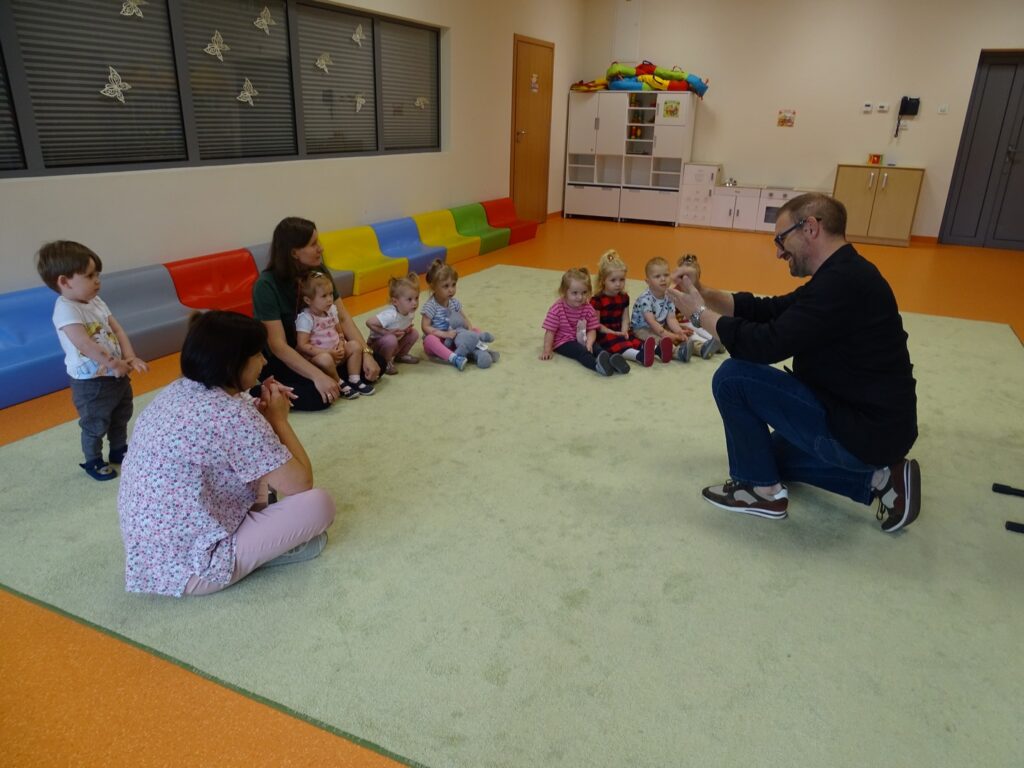 Dzieci wraz z Paniami siedzą na dywanie