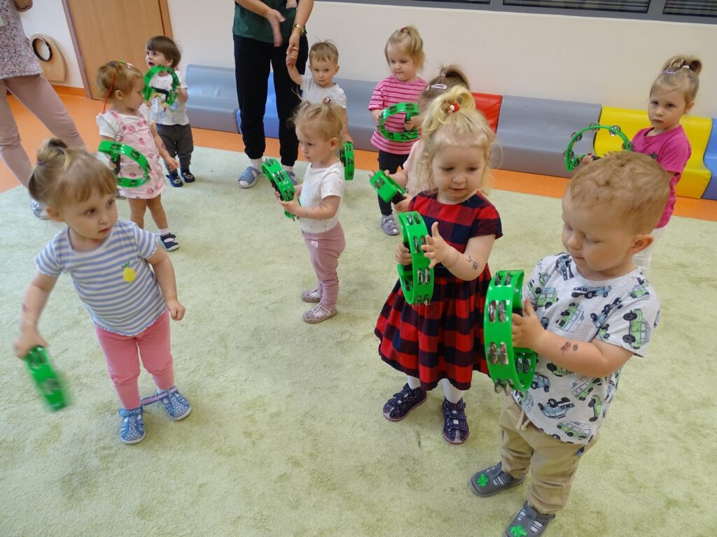 Dzieci trzymają zielone tamburyny