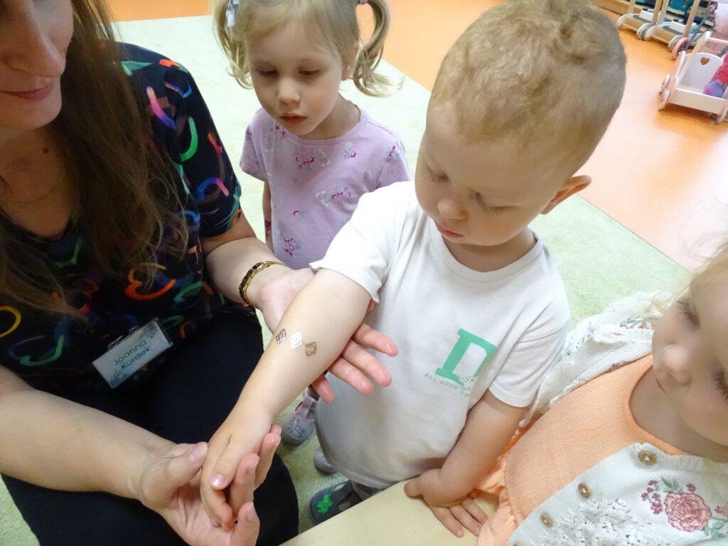 Dzieci przygladają się tatuażowi