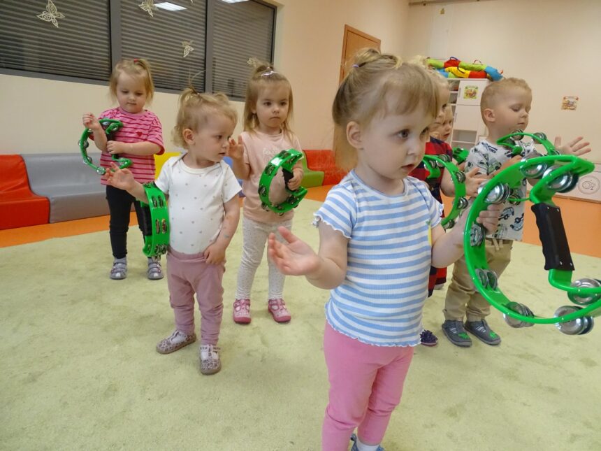 Dzieci na zajeciach z rytmiki grają na tamburynach