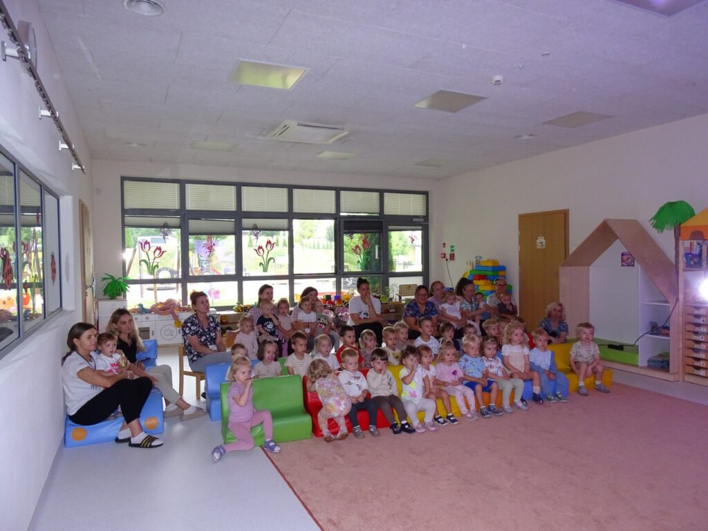Dzieci siedzą wraz z Paniami na kanapie