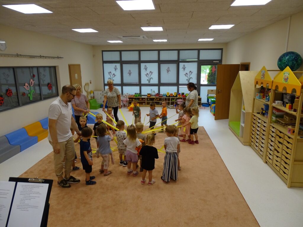 Dzieci tworzą słoneczko z żółtych szarf